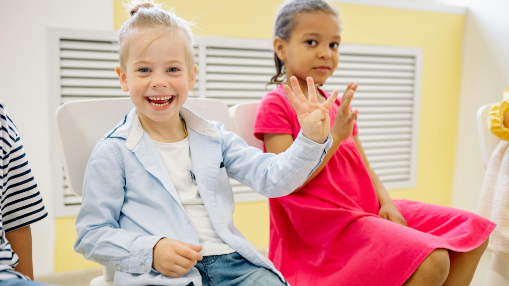two children at school waving