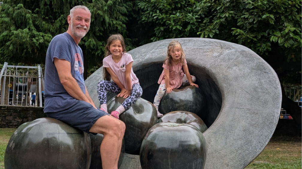 me and my grandkids sitting on an apple and hat sculpture